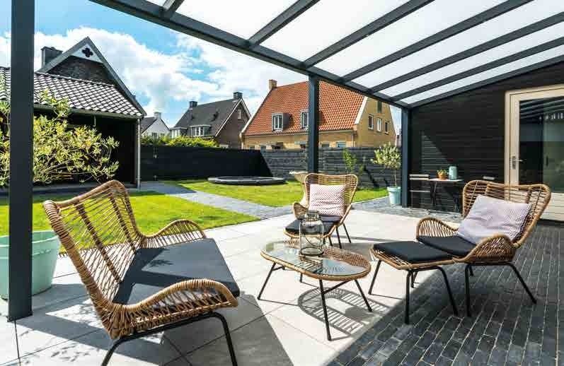 Finished aluminium veranda over a patio, set up for outdoor living