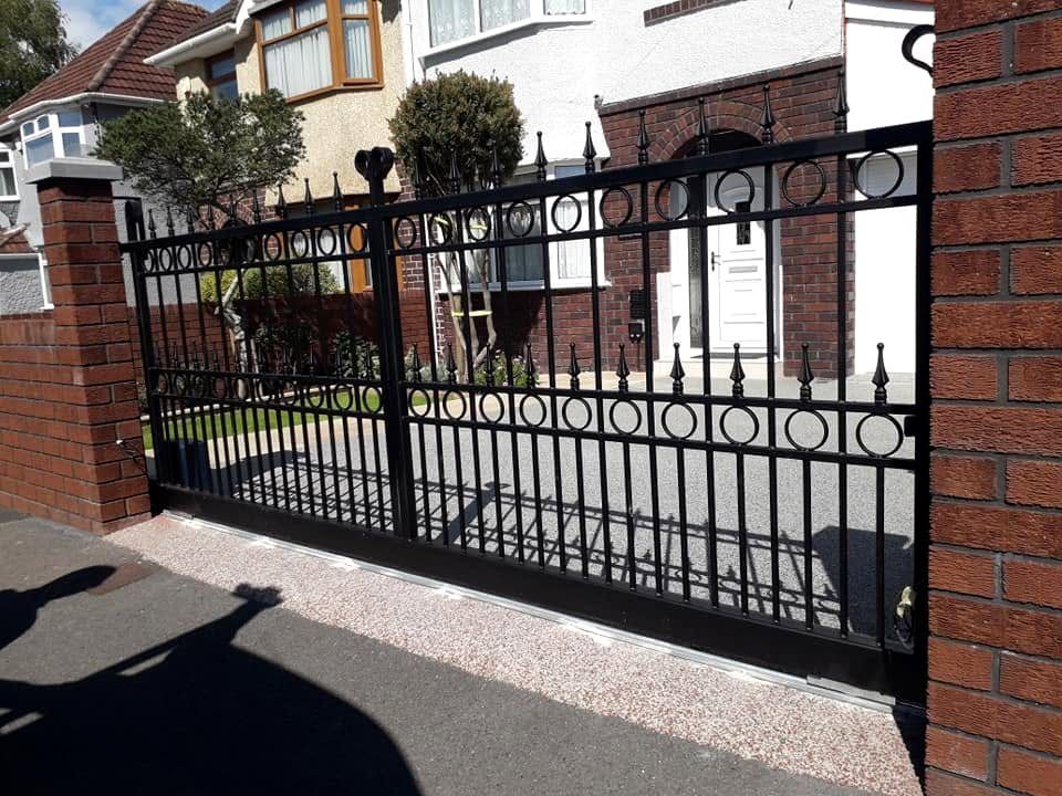 Wrought iron driveway gates with circle detail and spear tops