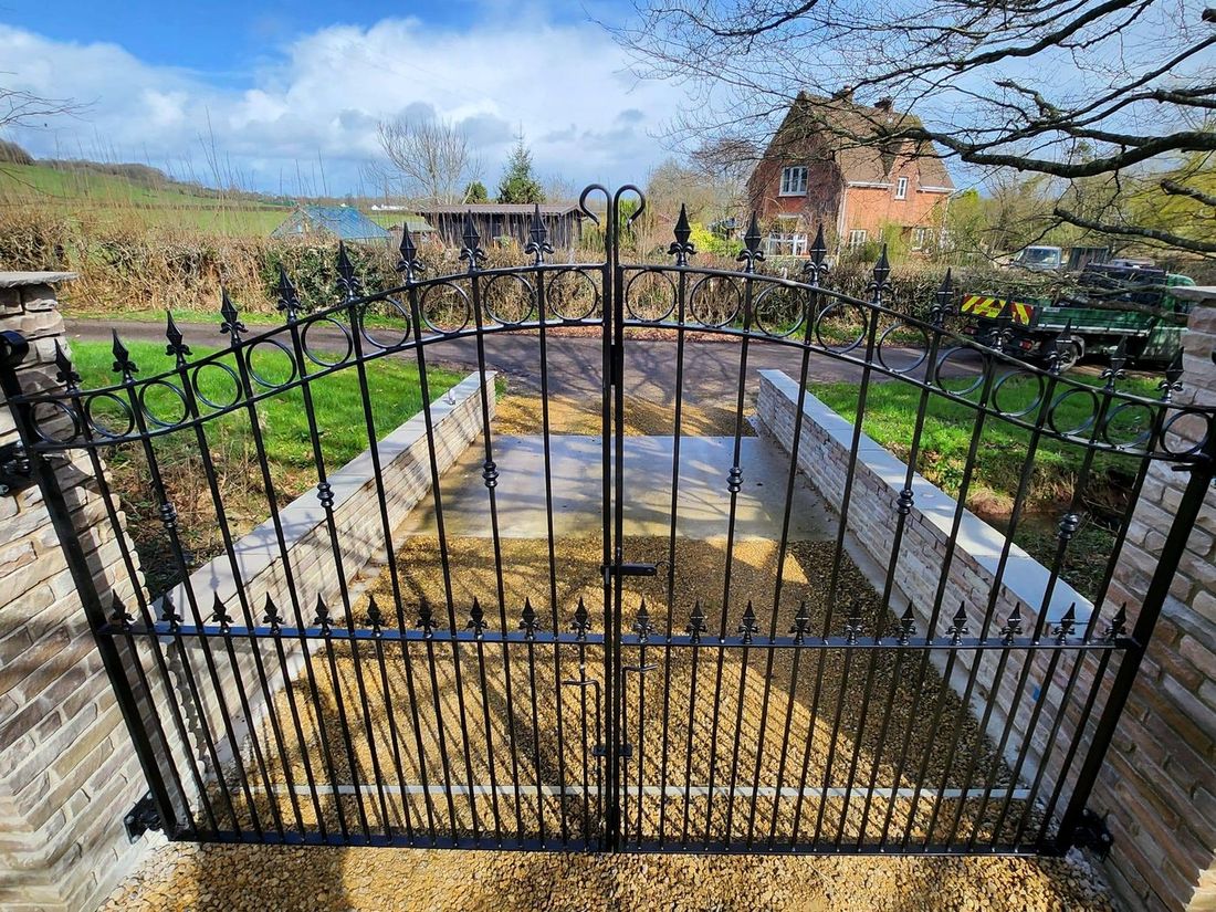 Wrought iron gates with fleur-de-lis finials and circle detail