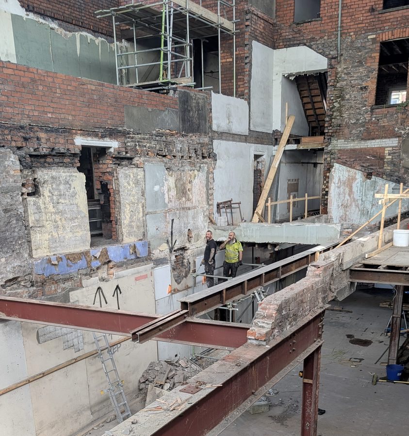 Long structural steel beam supported on a fabricated column inside the redevelopment